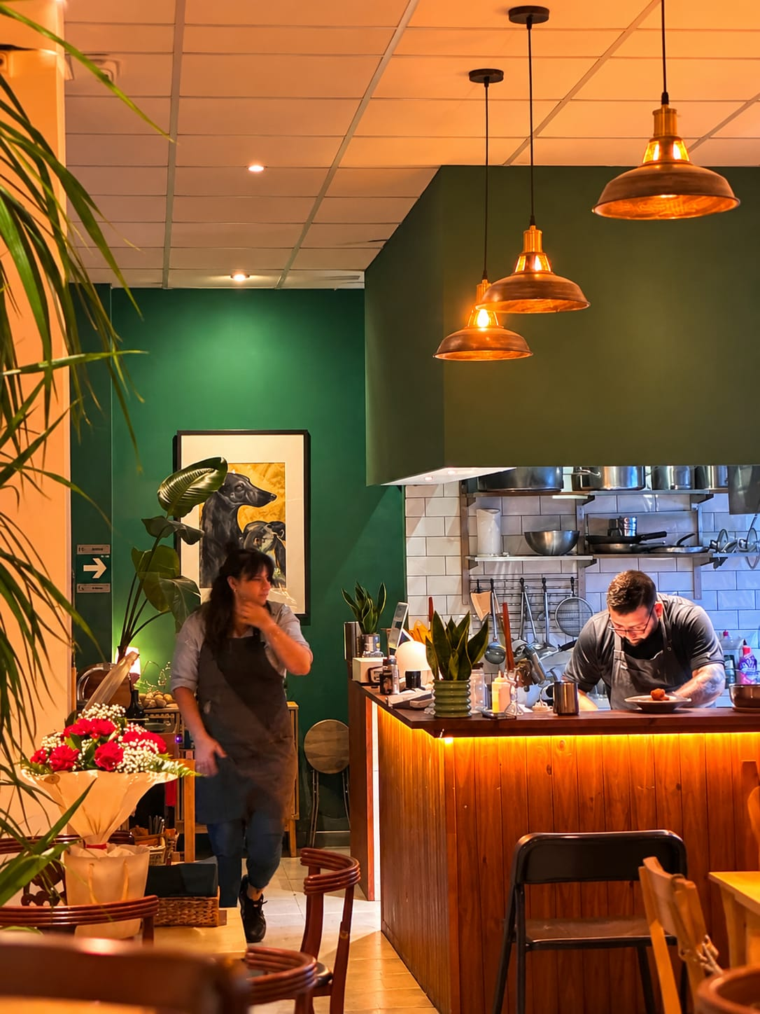 La cocinera y el chef de El Galgo trabajando en la cocina abierta